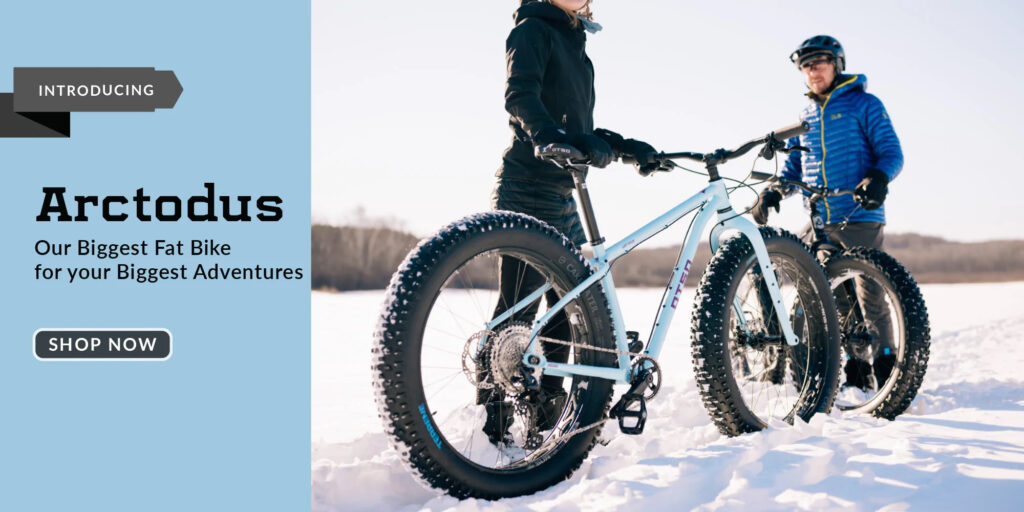 An advertisement for the Otso Cycles Arctodus fat bike. In the ad, two cyclists are standing with their Arctodus bicycles in the snow.