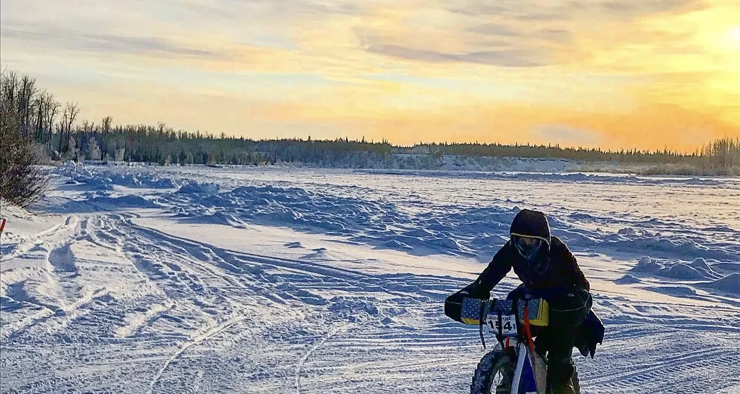 A cyclist rides their Otso Cycles Voytek fat bike across hard-packed Alaskan snow.