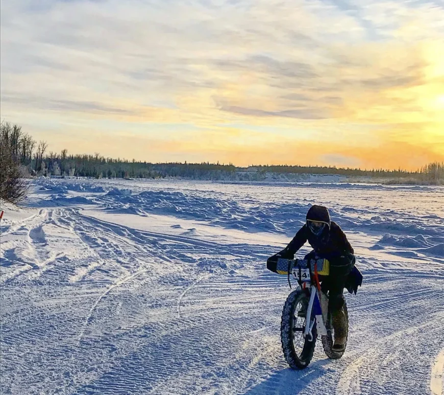 A cyclist rides their Otso Cycles Voytek fat bike across hard-packed Alaskan snow.