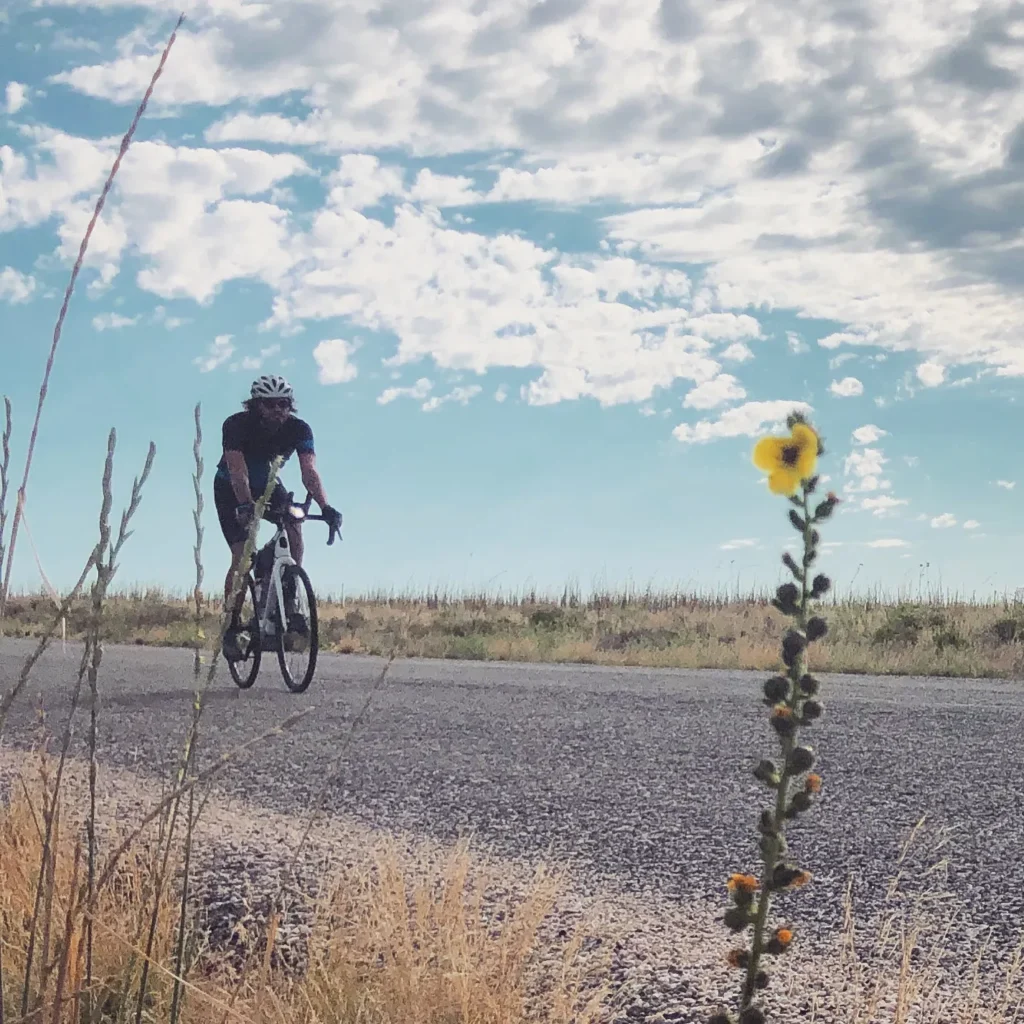 Brent Olson rides his Otso Cycles Waheela C along a paved road. 